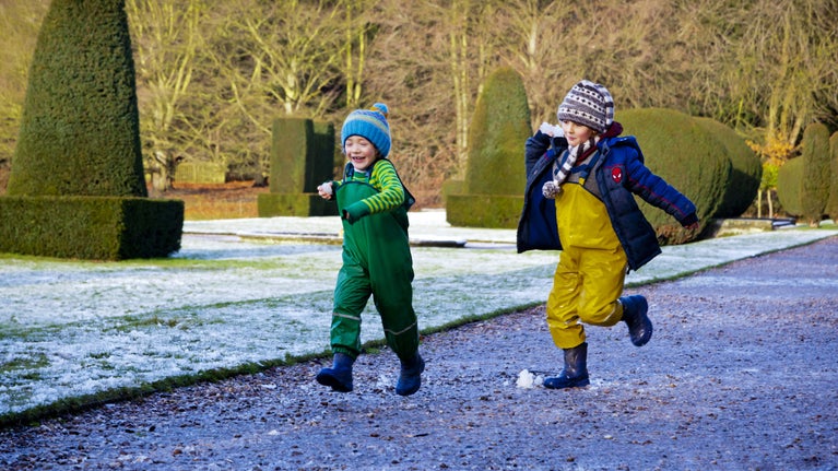 Children playing in the garden in winter at Sudbury Hall and the National Trust Museum of Childhood, Derbyshire